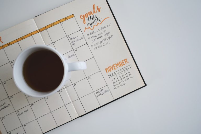 Agenda met planning en een kop koffie